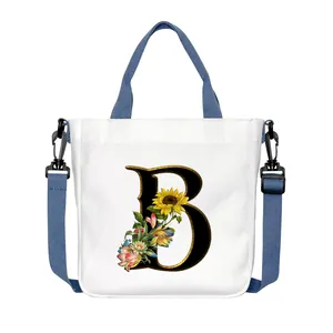 Borsa tote in tela bianca con lettera B floreale e tracolla blu regolabile