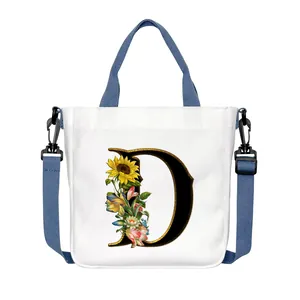 Borsa tote in tela bianca con lettera D floreale e tracolla blu regolabile