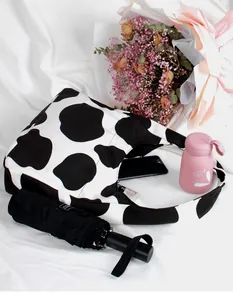 Vista detallada del interior del bolso de lona con estampado de vaca y su capacidad
