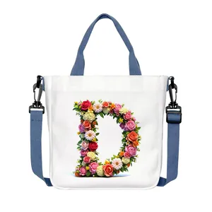 White canvas tote bag with floral letter D print, top handles and adjustable strap