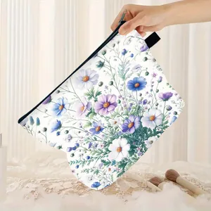 Hand holding floral cosmetic bag with purple cosmos print and black zipper closure