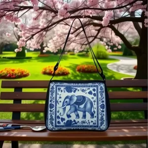 Detail of artistic elephant patterns and floral motifs on a blue-and-white tote bag