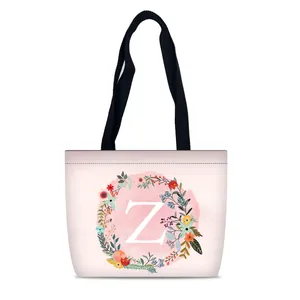 Macro detail of watercolor floral wreath and white letter Z on a pink canvas tote bag