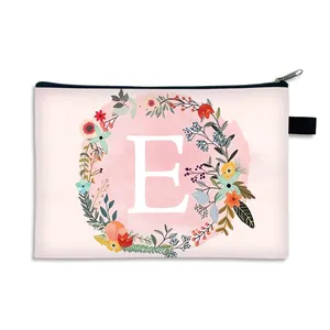 Pink makeup bag featuring floral letter E print and a black zipper for travel storage