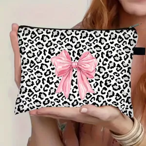 Leopard print makeup bag with pink bow held by hands, large capacity cosmetic storage pouch