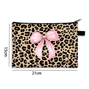 Flat makeup bag with leopard print and pink bow showing dimensions 21cm by 15cm