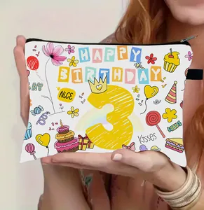 Dettaglio di una trousse da trucco bianca con motivi di compleanno e chiusura lampo nera