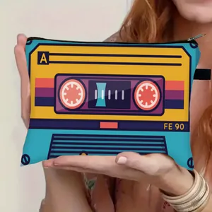 Portable makeup bag with vintage cassette tape print held by hands for travel storage