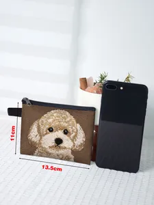 Detail showing the 13.5x11cm dog embroidery pouch next to a smartphone for size comparison