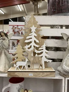 Detailed view of wooden Christmas tree and reindeer silhouettes with snow-like white paint