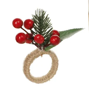Detalle de servilletero navideño con bayas rojas, agujas de pino y textura de cuerda