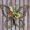 Detailed view of butterfly door wreath made of natural rattan with vibrant spring flowers