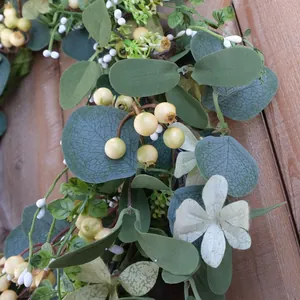 Detail of eucalyptus leaves and cream berries on a rustic wooden background