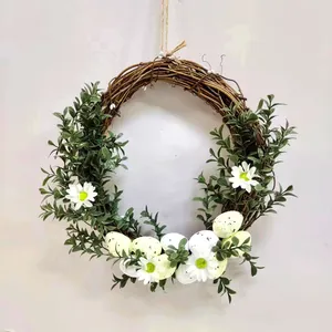 Ghirlanda pasquale in vite con uova colorate e margherite per decorazione porta