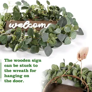 Corona de eucalipto y bayas con cartel welcome de madera para decoración del hogar