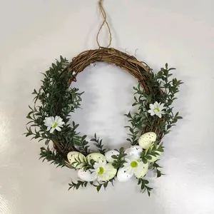 Dettaglio ghirlanda pasquale con margherite, foglie verdi e base in rattan naturale
