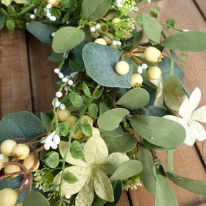 Large eucalyptus berry wreath with green leaves on dark wood for Easter decor