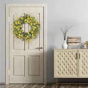 Daisy and eucalyptus floral wreath hanging on a white wooden door for home decor