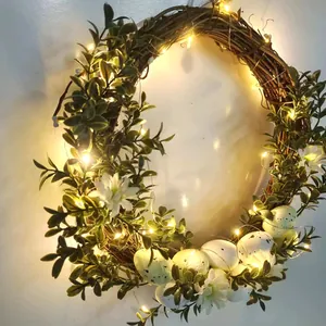 Dettaglio della ghirlanda pasquale con luci LED su base in rattan e uova colorate