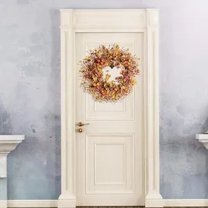 Macro detail of autumn wreath with orange silk flowers and berries on a white door
