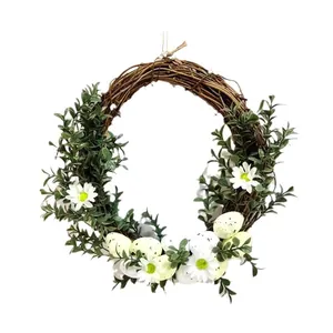 Ghirlanda di Pasqua in rattan naturale con uova colorate e margherite per la porta