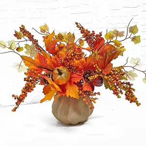 Autumn harvest decoration featuring faux pumpkins, maple leaves, and berries in a base