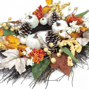 Autumn wreath with white pumpkins, pine cones, and maple leaves on a branch base