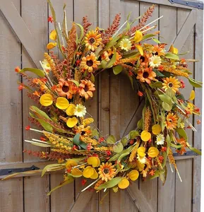 Close-up of autumn harvest wreath with sunflowers and daisies on a rustic wooden door