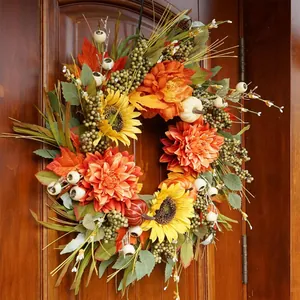 Détail de couronne d'automne avec tournesols et citrouilles sur une porte en bois