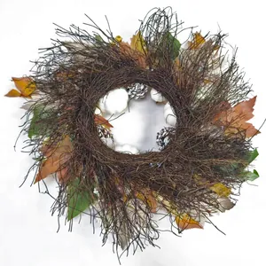 Detailed close-up of maple leaves, white pumpkins and pine cones on a rustic vine wreath