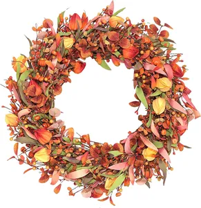 Detailansicht von herbstlichen Beeren und Ahornblättern auf einem rustikalen Kranz