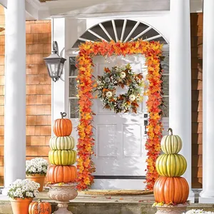 Autumn wreath and maple leaf garland with pumpkins for Thanksgiving front door decor
