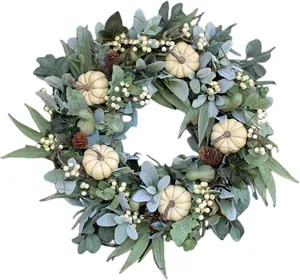 Détail de couronne d'automne avec citrouilles blanches, feuilles d'eucalyptus et pommes de pin