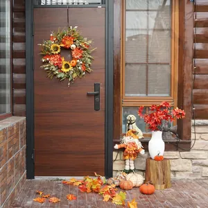 Couronne d'automne avec tournesols et citrouilles sur une porte en bois rustique