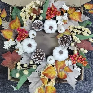 Autumn wreath with white pumpkins, pine cones and maple leaves in a kraft paper box