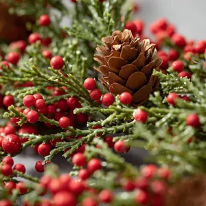 Corona de Navidad artificial con bayas rojas, piñas y ramas de cedro verde