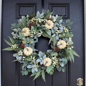 Autumn wreath with cream pumpkins, pine cones and white berries for outdoor home decoration
