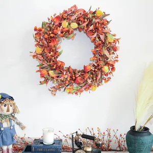 Herbstkranz mit orangefarbenen Beeren und Ahornblättern für die Erntedankfest Haustürdeko
