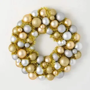 Detail of Christmas wreath with gold and silver ornaments on a white background