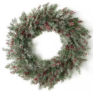Detalle de corona de Navidad escarchada con agujas de pino y bayas rojas de acebo vibrantes