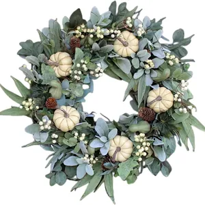 Autumn wreath with white pumpkins, pine cones and berries on green foliage for door decor