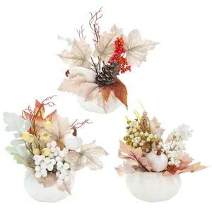 Trois citrouilles en mousse blanche avec feuilles d'automne et baies pour décorations