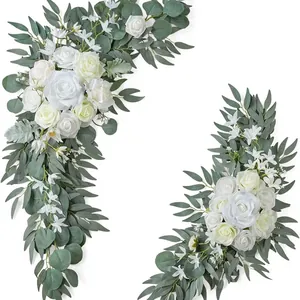 Close-up detail of white silk roses and eucalyptus leaves for wedding arch decor