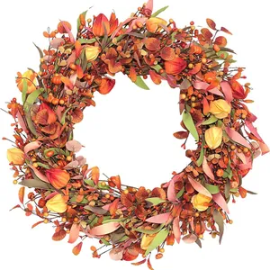 Couronne d'automne avec feuilles d'érable, baies et citrouilles pour déco de porte