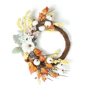 Couronne d'automne avec citrouilles blanches, feuilles d'érable et baies sur brindilles