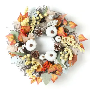 Couronne d'automne avec citrouilles blanches, pommes de pin et feuilles d'érable colorées