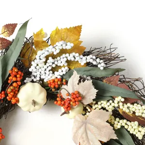Gros plan détaillé d'une couronne d'automne avec citrouilles blanches et baies rouges
