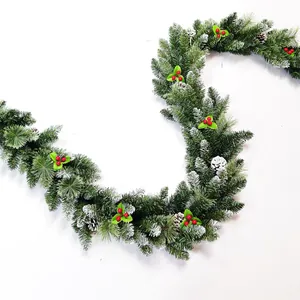 Artificial Christmas pine garland with red berries, pinecones and snowy flocked needles