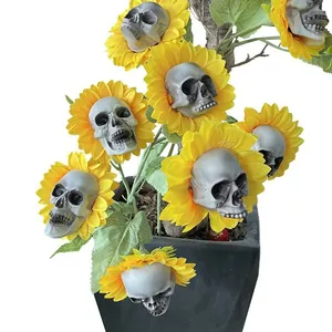 Gothic artificial sunflower with skull centers and green leaves in a black square pot