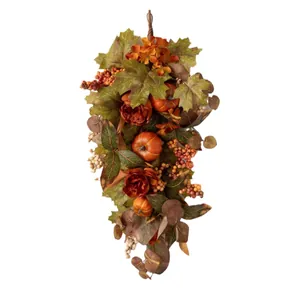 Autumn swag decoration with artificial sunflowers, maple leaves, and berries on white backdrop